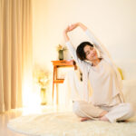 寝る前にストレッチをして肩や首をほぐしている女性