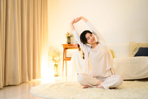 寝る前にストレッチをして肩や首をほぐしている女性