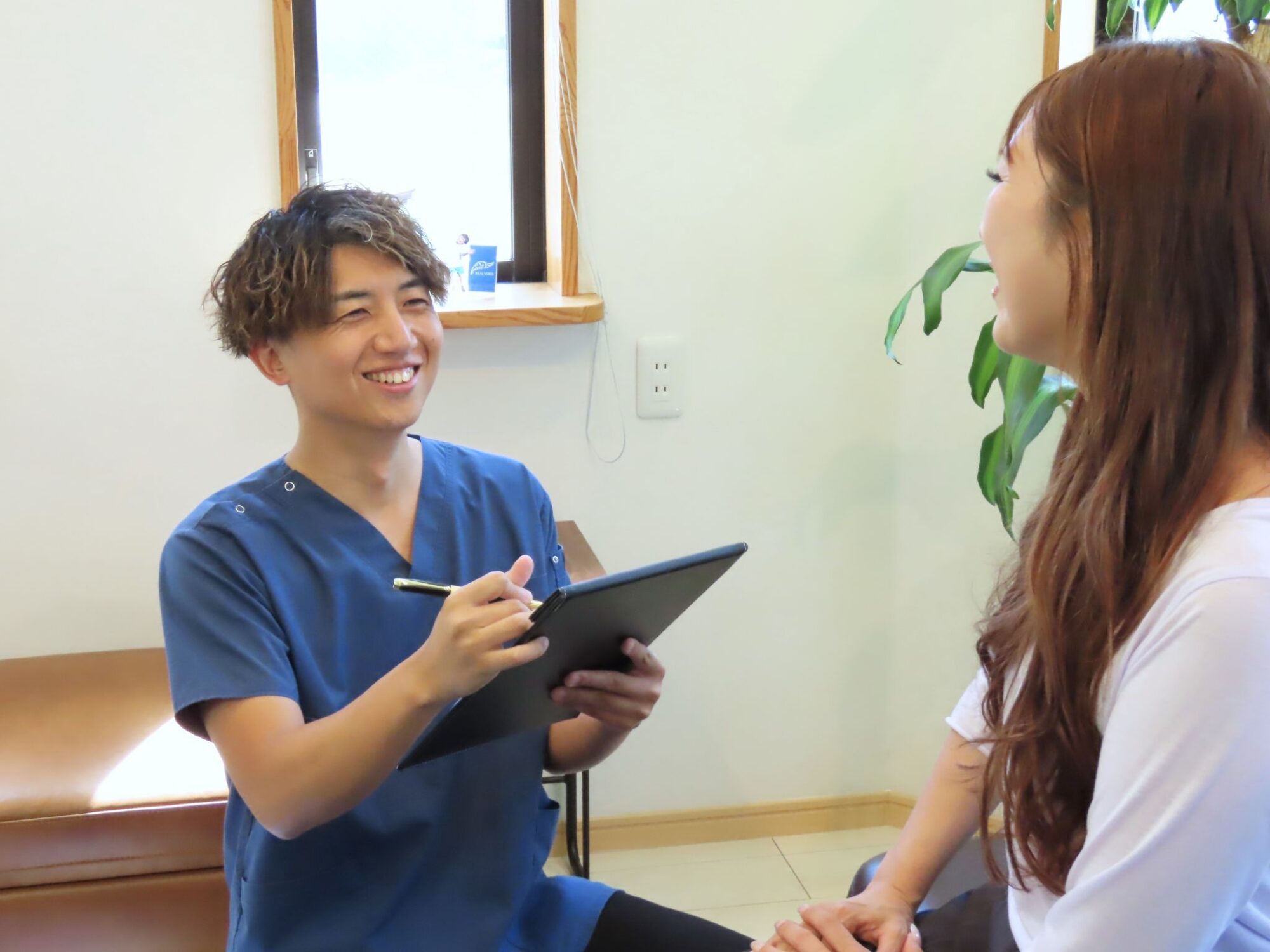 佐々木さんがタブレットを使ってカウンセリングしている様子